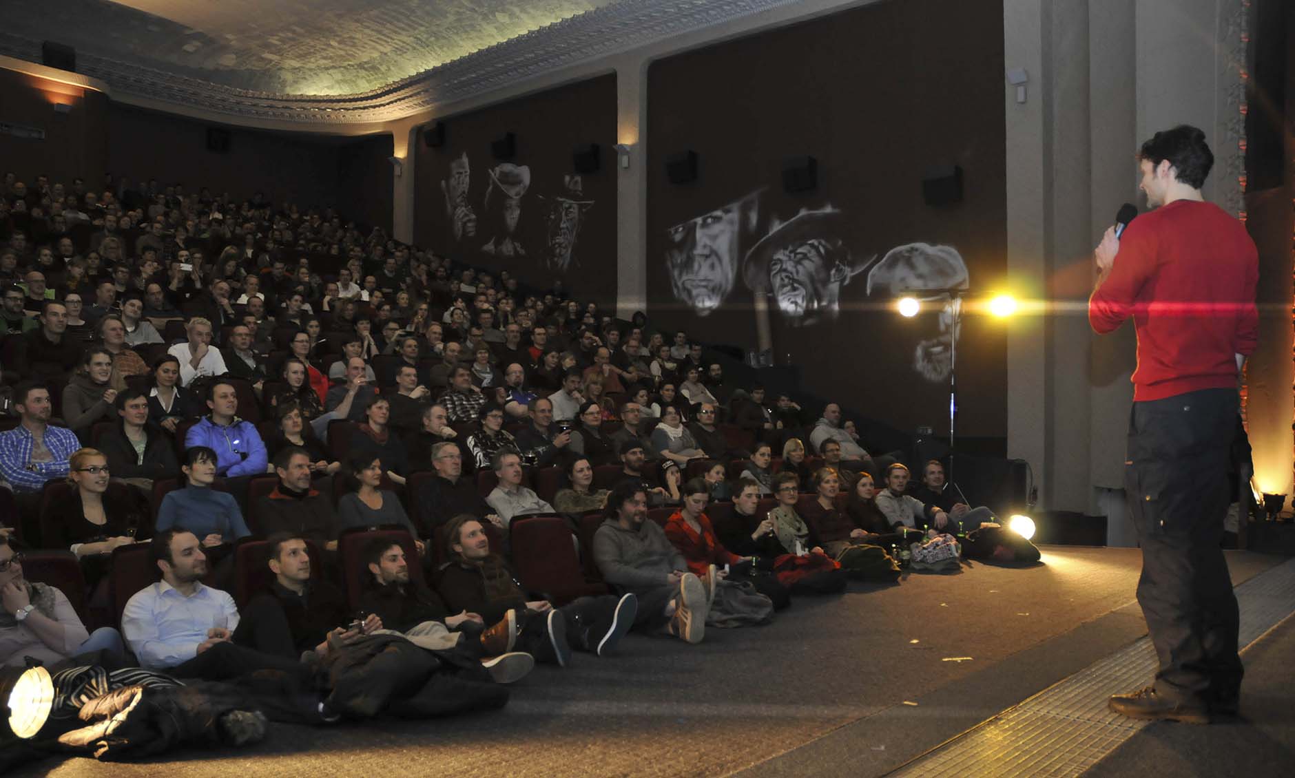 Daniel Rintz speaking in front of a large audience during a movie premiere